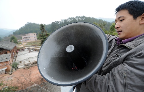 技术人员在定南县岭北镇梅香村安装高音喇叭